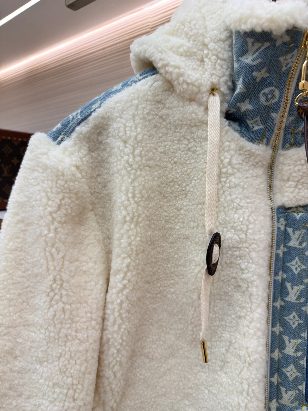 LOUIS VUITTON Letter jacquard splicing lamb wool ski hooded jacket ●Original version: purchased and developed by 26909 ●Item number: 1682241-C35 ●Fabric: lamb wool fabric ●Technology: jacquard production ●Color: off-white ●Version: fitted version ●Weight: about 1245 grams ●Size: 34-36-38-40-42-44 ●Description: The main body of this lamb wool spliced denim jacket is made of imported imitation lamb wool fabric, which has been processed by carding and shaping processes. The wool feels fluffy and soft and is not easy to shed and pill. The fabric has a uniform weight and has both warmth retention and breathability. The neckline, placket and chest pockets are spliced ​​with classic presbyopic denim. The denim is enzymatically washed to create a natural aged texture. The presbyopic pattern is embossed, making the texture three-dimensional and not easy to fall off. The body adopts a loose hooded fit, with a built-in shaping lining on the brim and an adjustable drawstring design; a custom metal zipper is used at the placket, and the chain teeth are gold-plated for smooth pulling and anti-oxidation. The edges of the pockets are reinforced with double stitching, and the splicing of lambswool and denim is made by hand caulking. The stitching is fine and smooth. Every detail is strictly controlled, showing the craftsmanship and quality of high-end clothing. The overall wiring is straight and delicate, the fabric is comfortable and soft, and the color is consistent without color difference. It can be matched with the same style to create a fashionable look and control various occasions. Customized accessories, complete with three standards, same style for men and women!